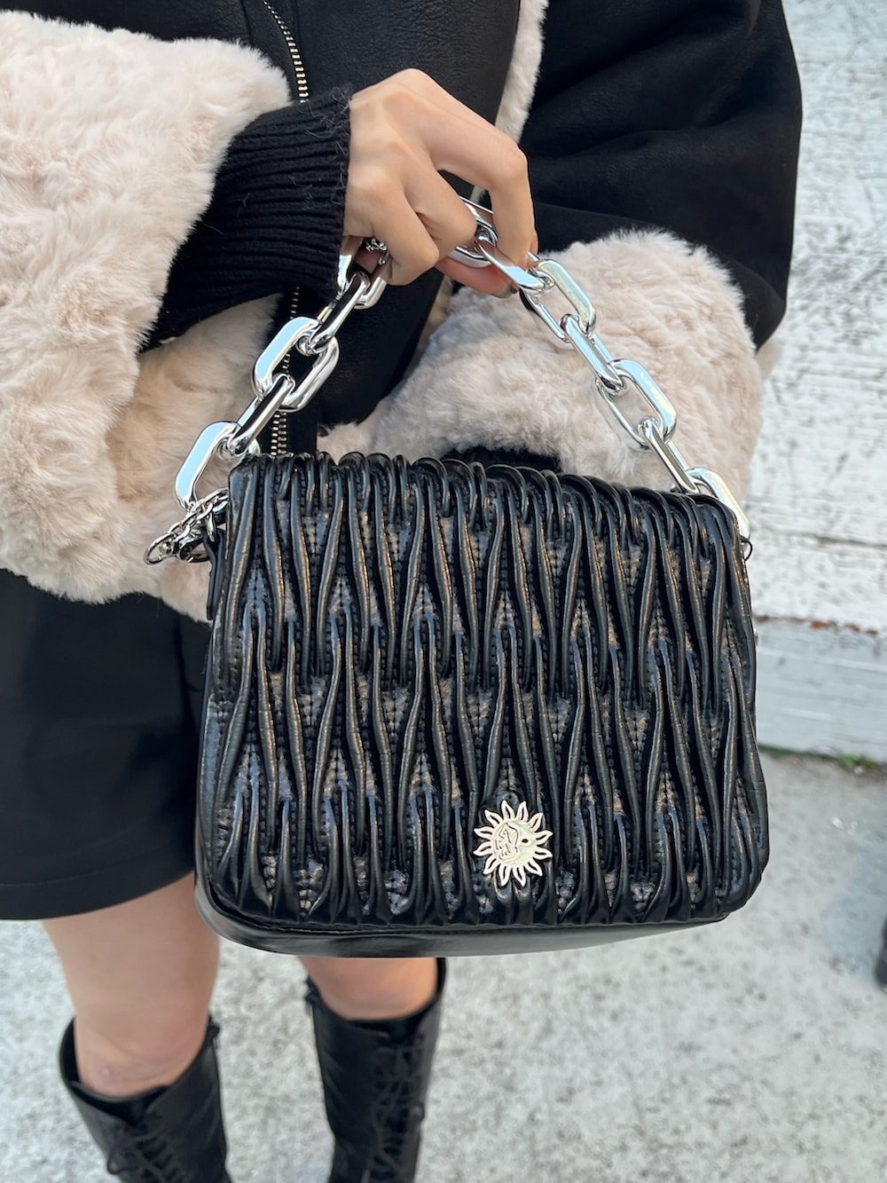 ブラック系のブーツ、シルバー系のショルダーバッグ、グリーン系のムートンコートを着用したレディースの冬コーディネートの5枚目の写真