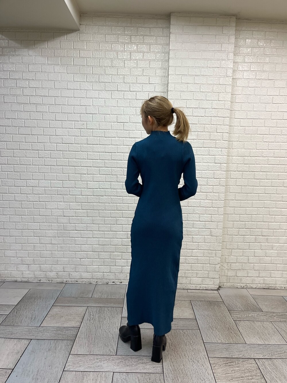 ブラック系のブルゾン、ブラック系のショルダーバッグ、ブルー系のワンピースを着用したレディースの冬コーディネートの5枚目の写真