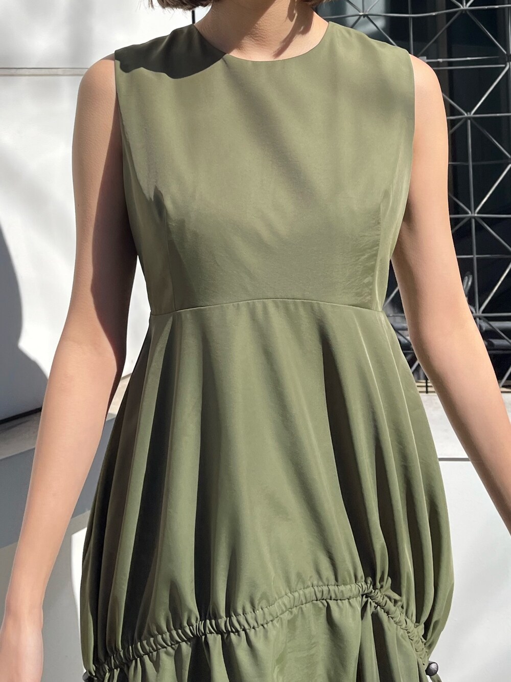 グリーン系のワンピース、ホワイト系のサンダルを着用したレディースの春コーディネートの4枚目の写真