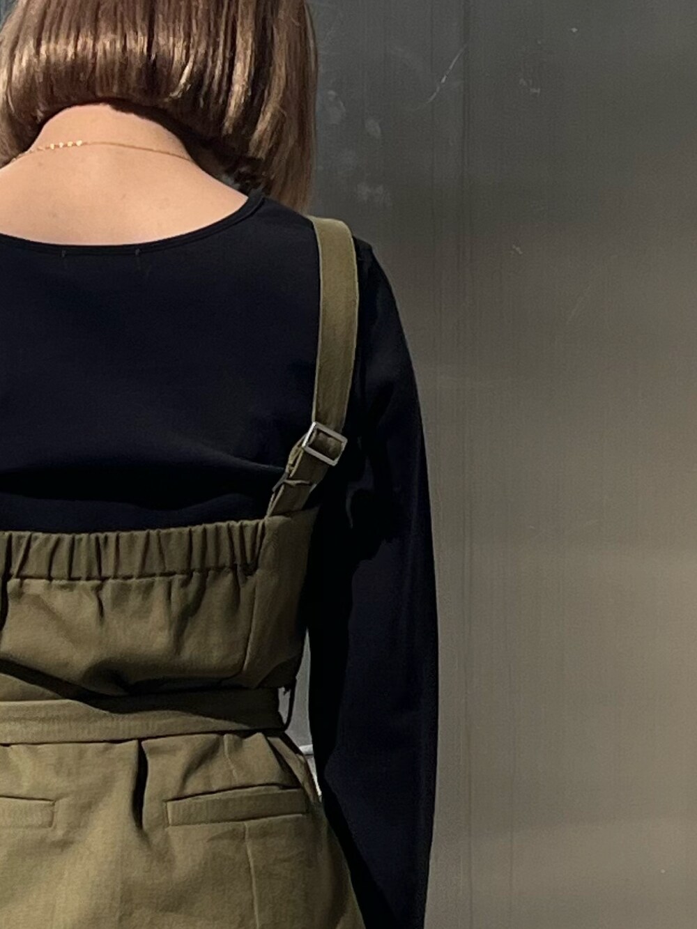 ブラック系のワンピース、ブラック系のショルダーバッグ、ブラック系のブーツを着用したレディースの冬コーディネートの6枚目の写真