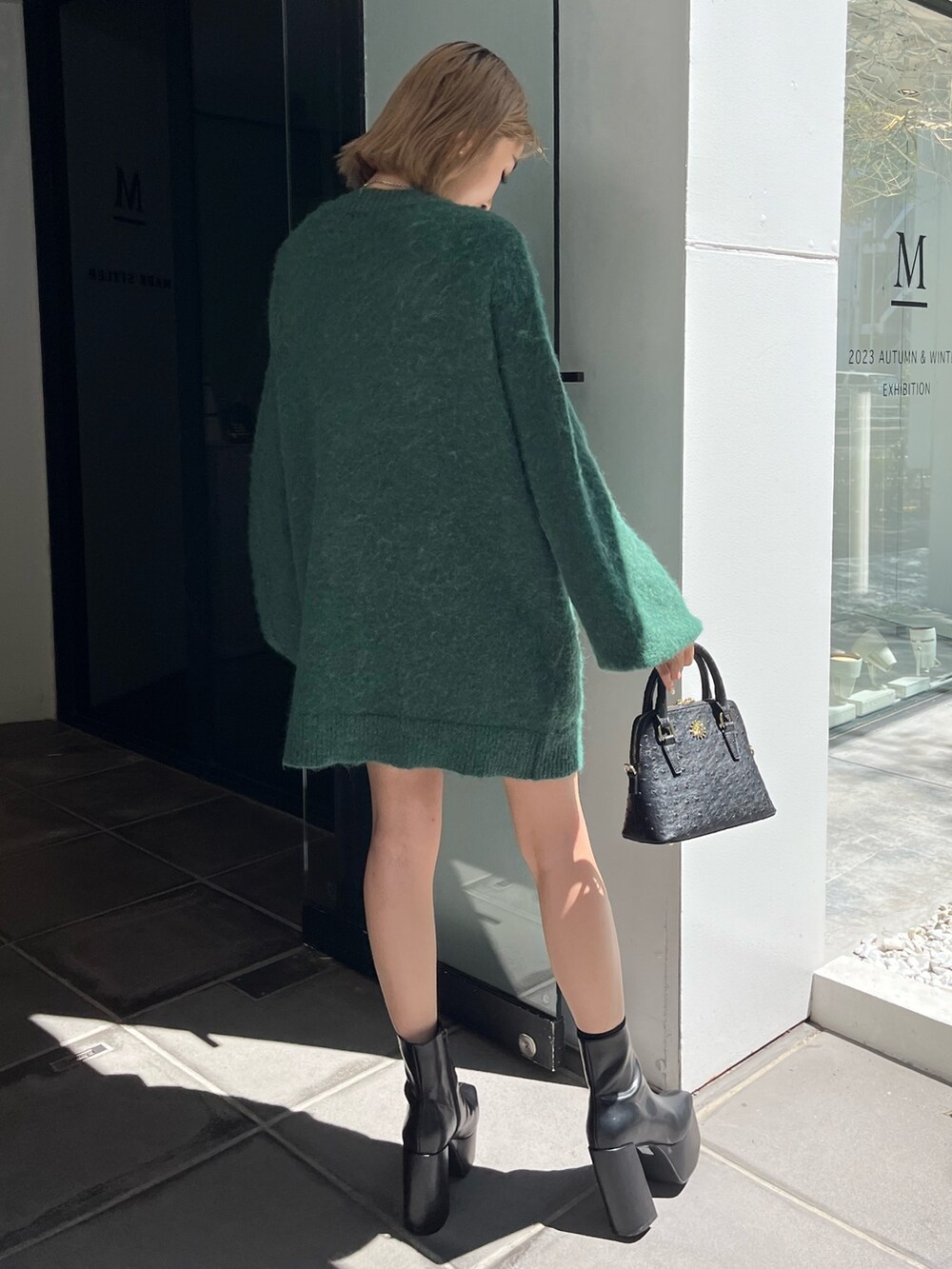 ブラック系のブーツ、ブラック系のショルダーバッグ、グリーン系のカーディガン/ボレロを着用したレディースの秋コーディネートの4枚目の写真
