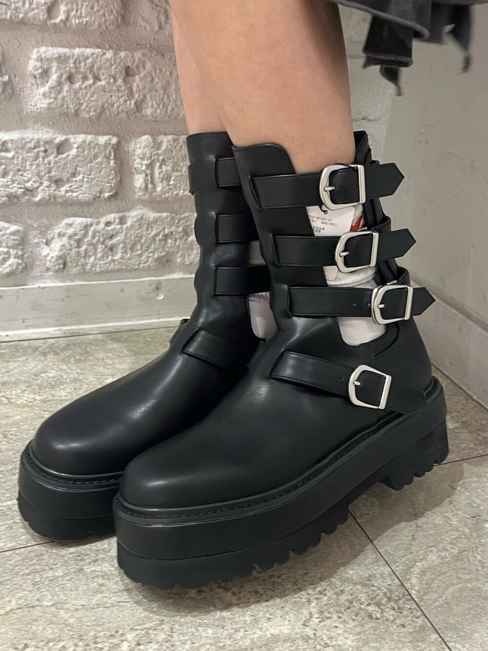 ブラック系のスウェット、ブラック系のスカート、ブラウン系のハンドバッグを着用したレディースの春コーディネートの8枚目の写真