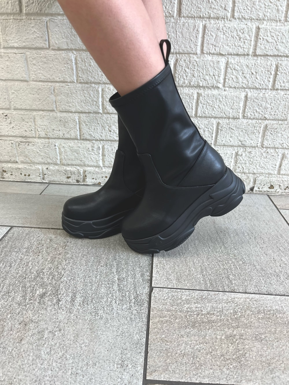 ブラック系のブーツ、ホワイト系のダウンジャケット/コート、ブラック系のショルダーバッグを着用したレディースの冬コーディネートの8枚目の写真