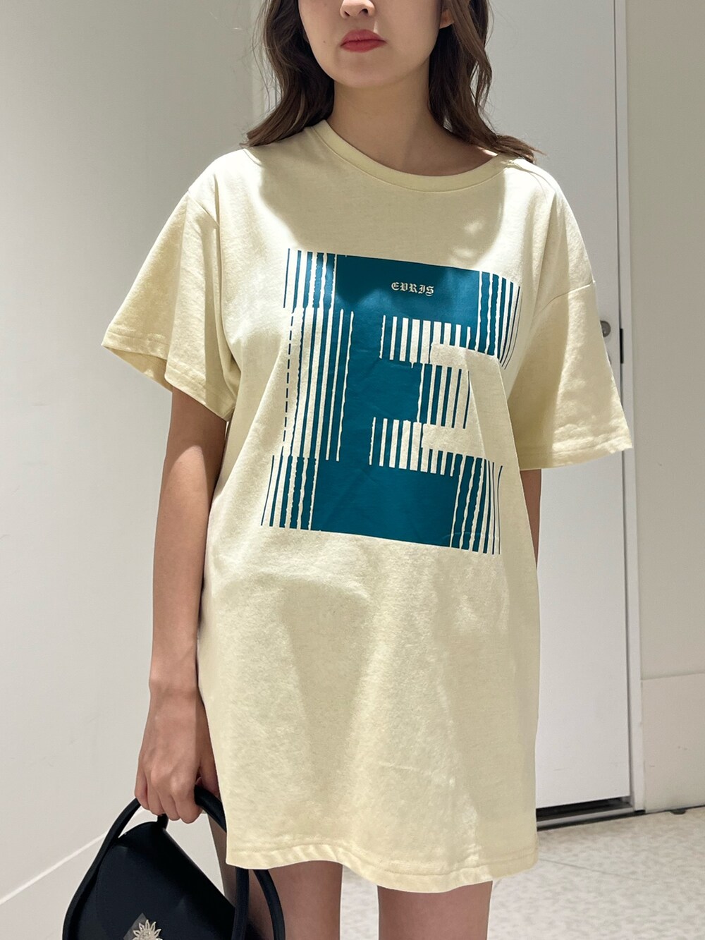 ブルー系のTシャツ/カットソー、ブラック系のハンドバッグ、ブラック系のブーツを着用したレディースの春コーディネートの5枚目の写真