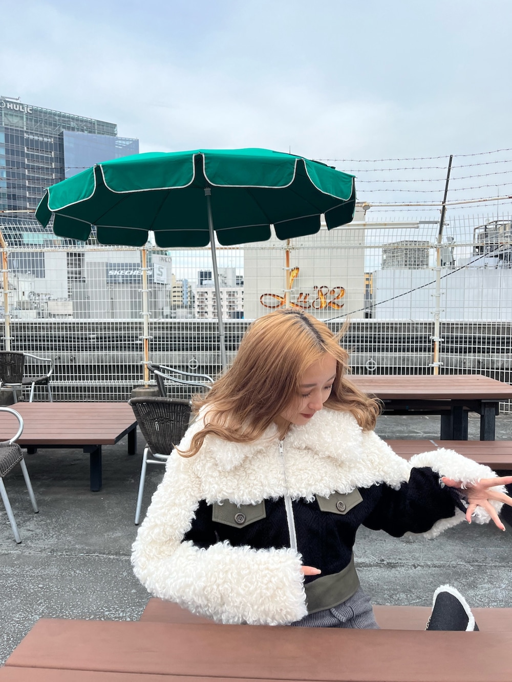 ホワイト系のブルゾン、グレー系のワンピース、ブルー系のショルダーバッグを着用したレディースの秋コーディネートの6枚目の写真