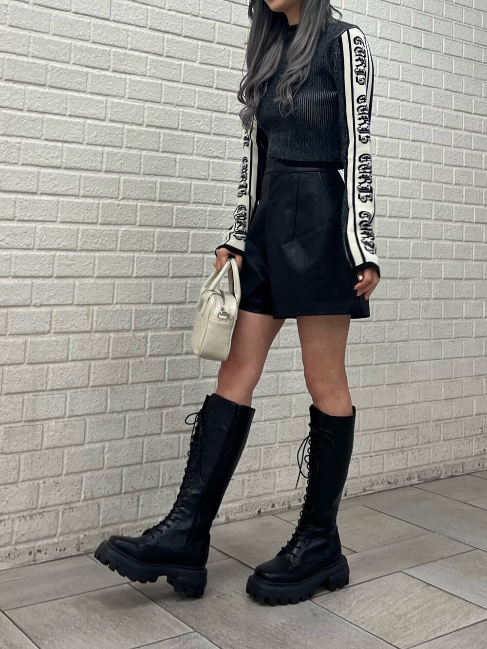ベージュ系のその他パンツ、ブラック系のブーツ、ブラック系のショルダーバッグを着用したレディースの冬コーディネートの5枚目の写真