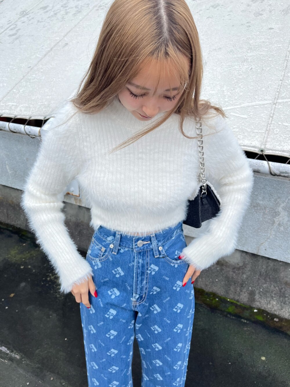 ホワイト系のニット/セーター、ブルー系のデニムパンツ、ブラック系のブーツを着用したレディースの秋コーディネートの4枚目の写真