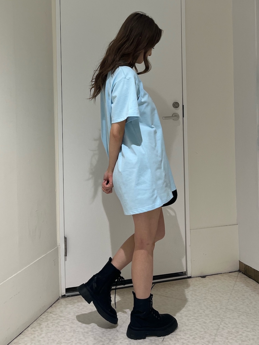 ブラック系のハンドバッグ、ブラック系のブーツ、ブルー系のTシャツ/カットソーを着用したレディースの春コーディネートの5枚目の写真