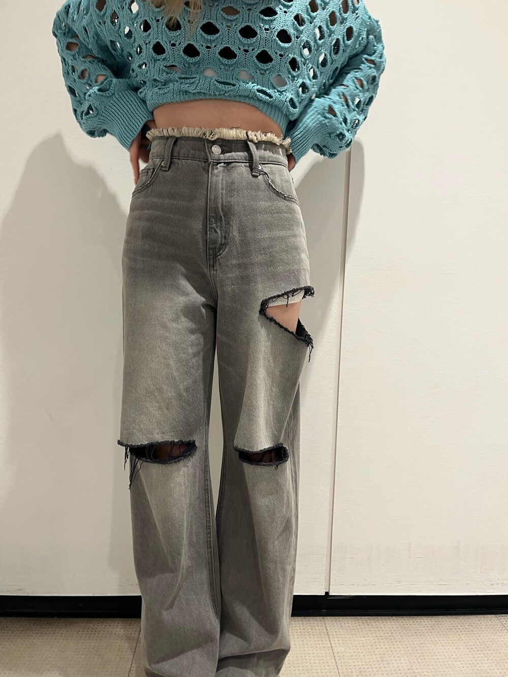 ブラック系のデニムパンツ、ブラック系のブーツ、ブルー系のニット/セーターを着用したレディースの冬コーディネートの5枚目の写真