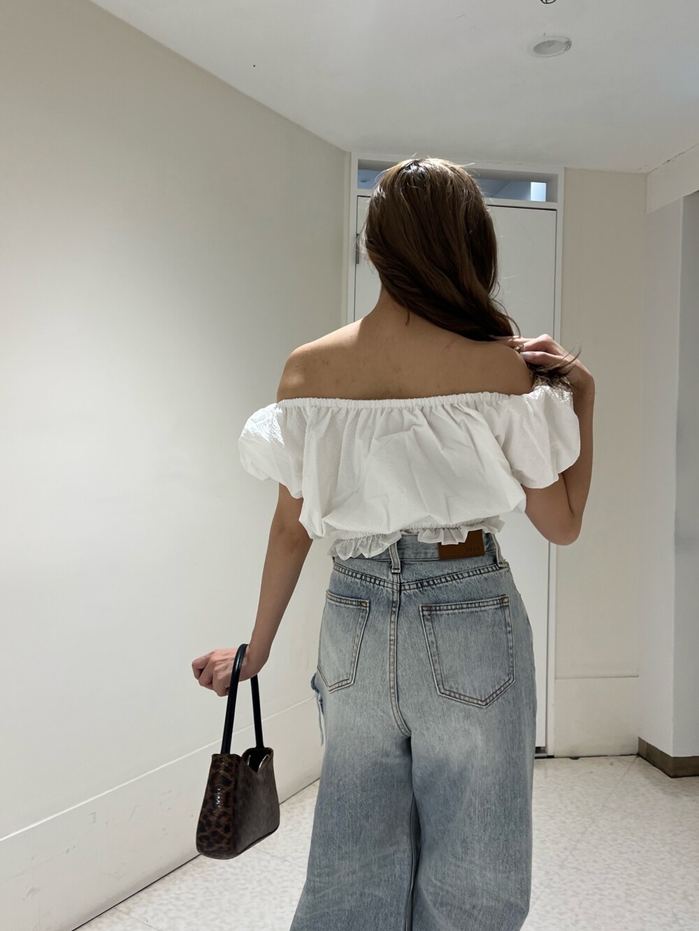ホワイト系のシャツ/ブラウス、ブルー系のデニムパンツ、ブラウン系のハンドバッグを着用したレディースの夏コーディネートの5枚目の写真