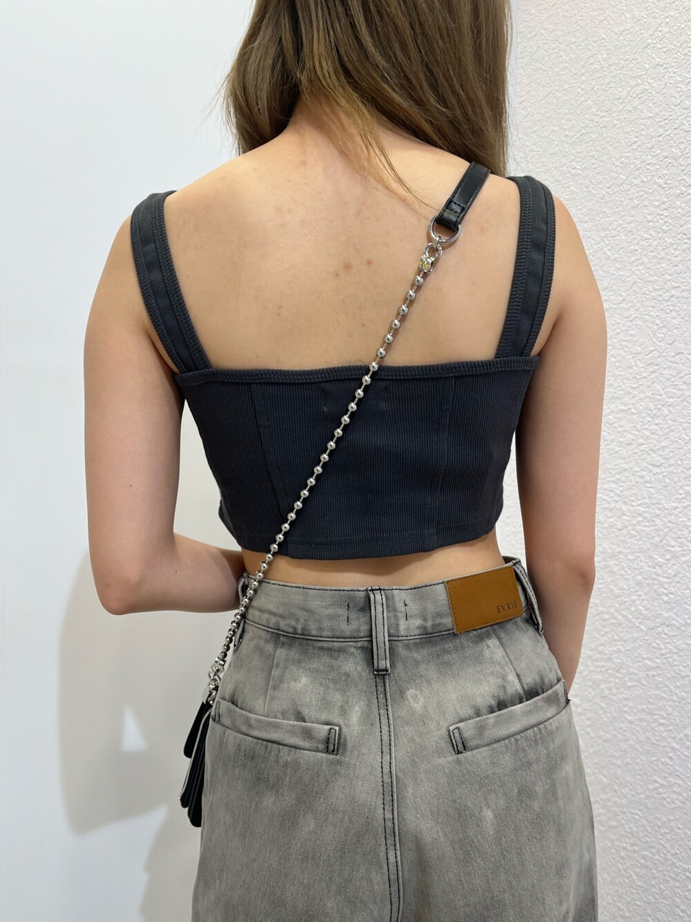 シルバー系のショルダーバッグ、ブラック系のキャミソール、ブラック系のデニムパンツを着用したレディースの夏コーディネートの7枚目の写真