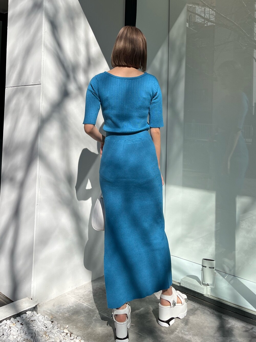 ブルー系のワンピース、ブラック系のハンドバッグを着用したレディースの春コーディネートの3枚目の写真