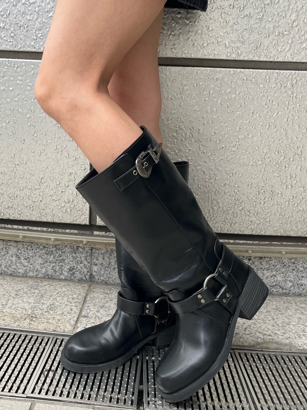 ブラック系のブーツ、ブラック系のデニムスカート、ブルー系のニット/セーターを着用したレディースの秋コーディネートの6枚目の写真
