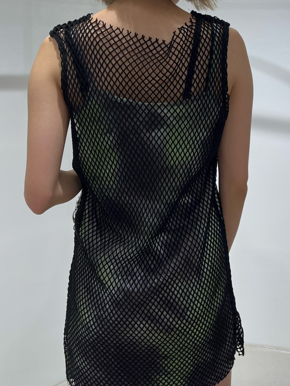 グリーン系のワンピース、ブラック系のサンダル、ブラック系のショルダーバッグを着用したレディースの春コーディネートの5枚目の写真