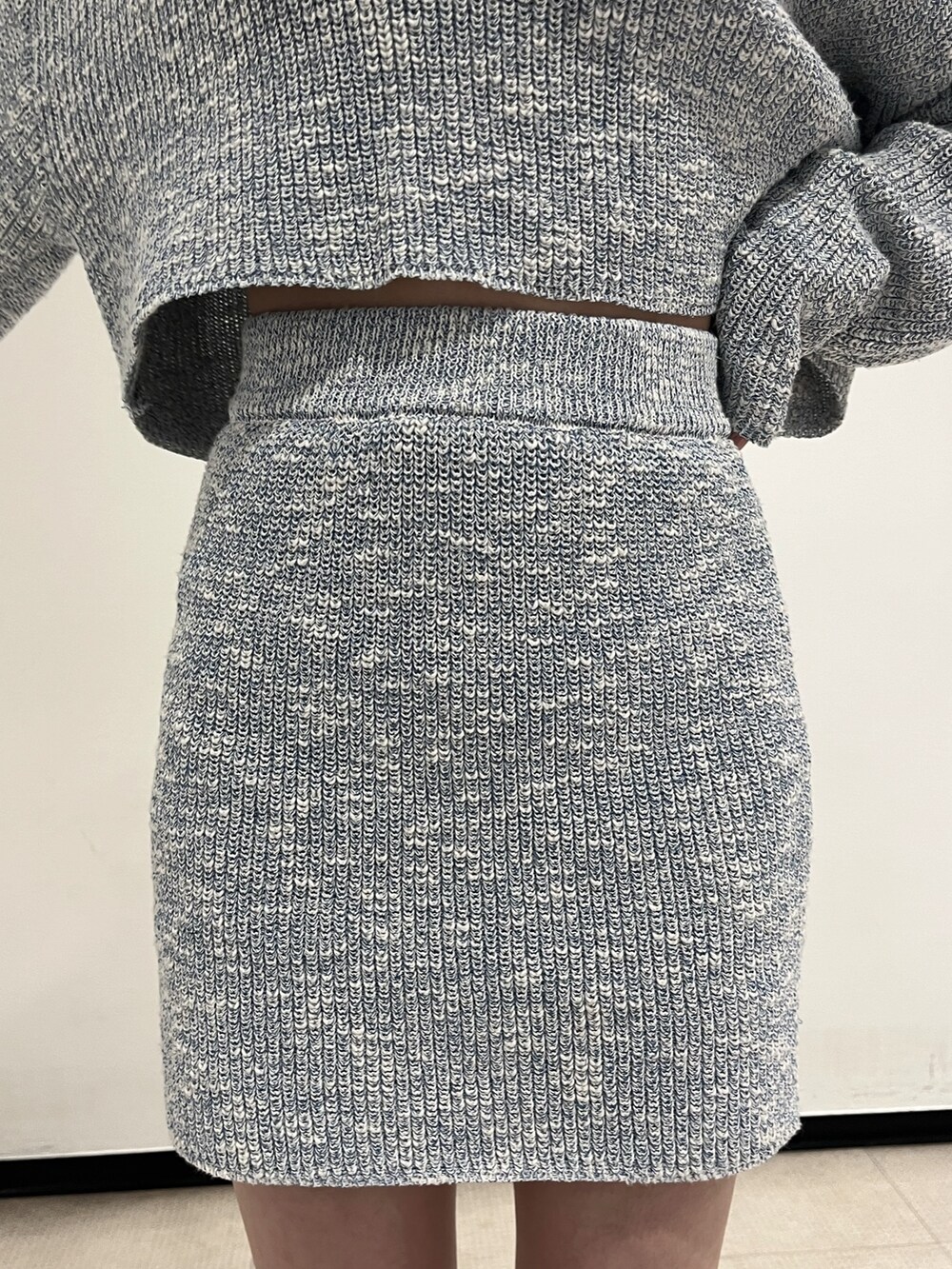 シルバー系のボディバッグ/ウエストポーチ、シルバー系のブーツ、ブルー系のワンピースを着用したレディースの春コーディネートの7枚目の写真