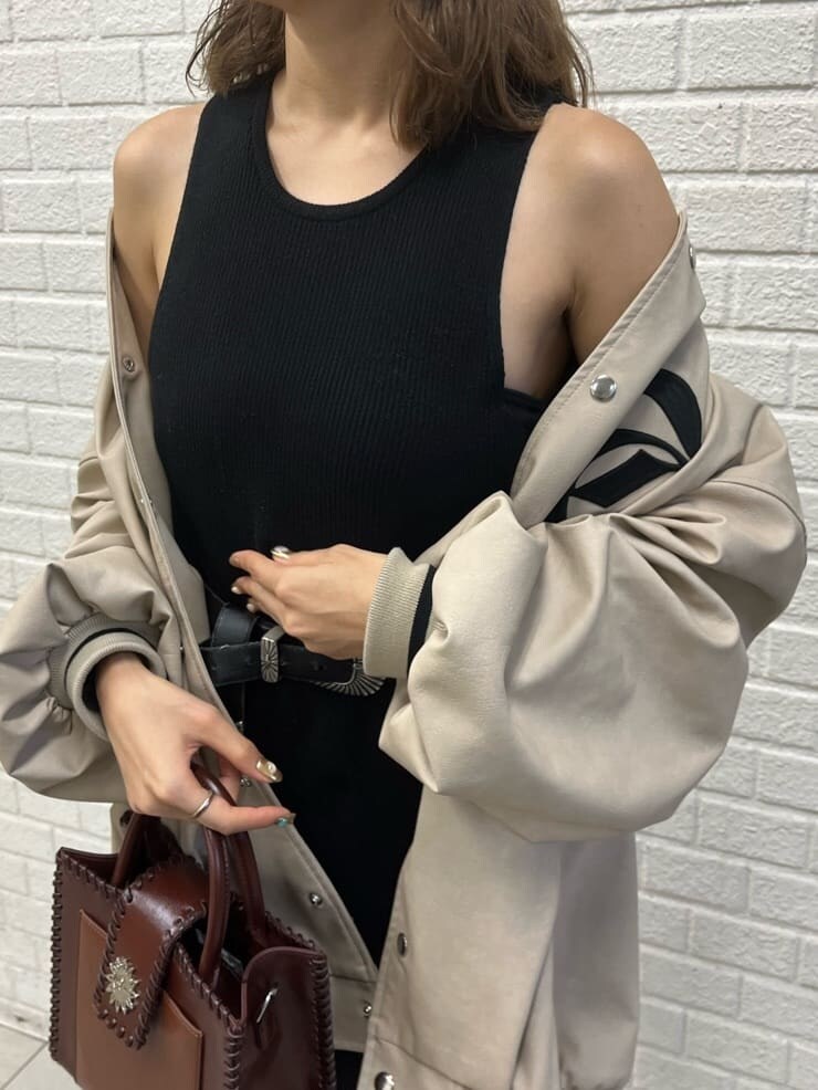 ブラック系のワンピース、ブラック系のブーツ、ベージュ系のブルゾンを着用したレディースの秋コーディネートの6枚目の写真