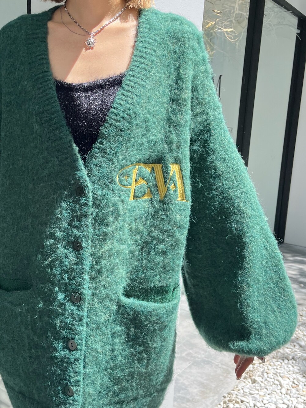 ブラック系のブーツ、ブラック系のショルダーバッグ、グリーン系のカーディガン/ボレロを着用したレディースの秋コーディネートの5枚目の写真