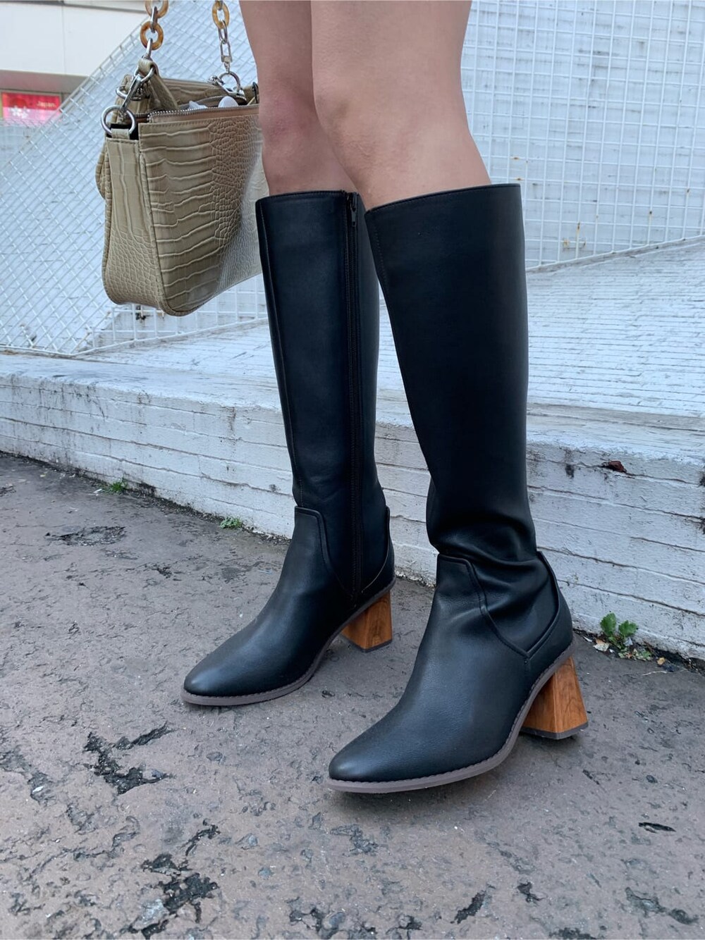 ホワイト系のショルダーバッグ、ブラック系のブーツ、ブラック系のシャツ/ブラウスを着用したレディースの冬コーディネートの4枚目の写真