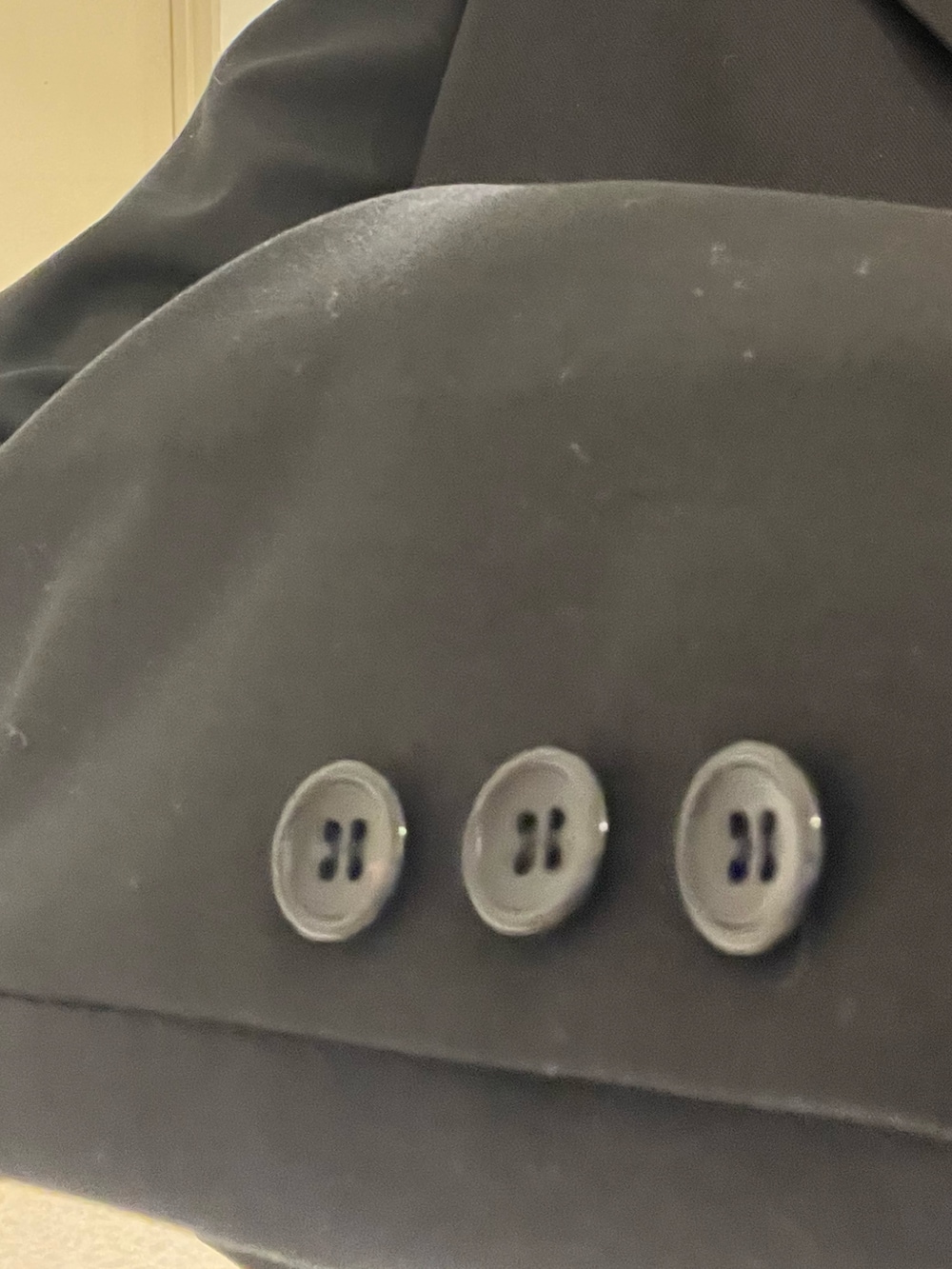 ブラック系のテーラードジャケット、ブラック系のワンピース、ブラック系のブーツを着用したレディースの春コーディネートの5枚目の写真