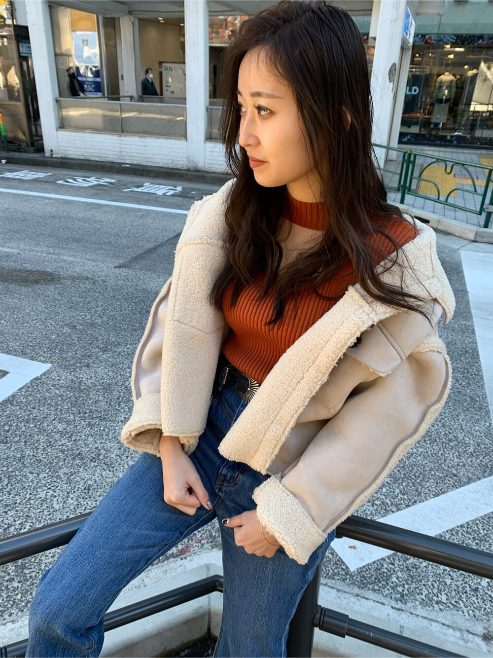 ブラック系のブーツ、ホワイト系のブルゾン、ブルー系のデニムパンツを着用したレディースの冬コーディネートの2枚目の写真