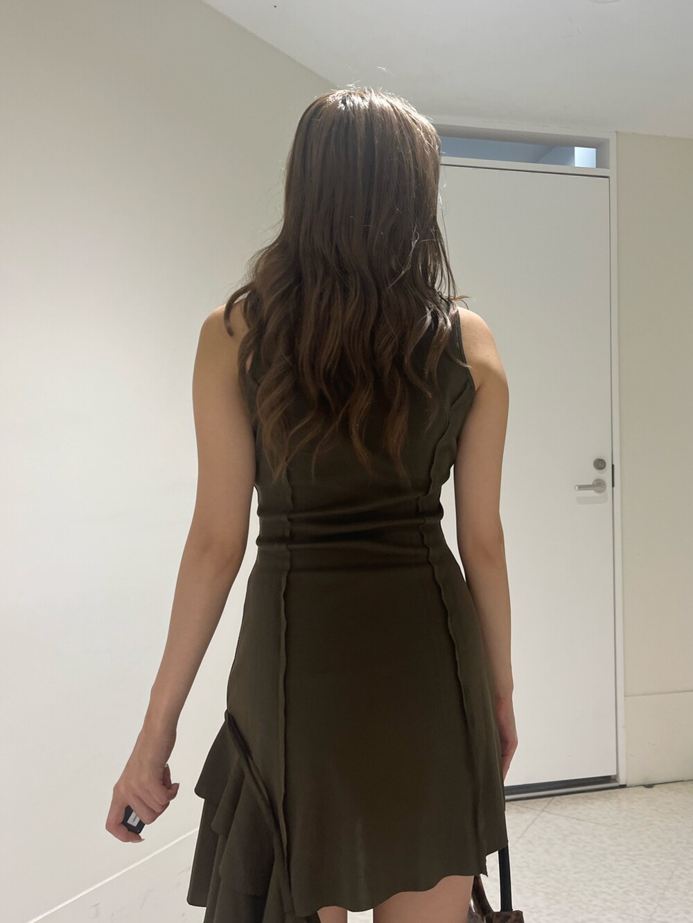 グリーン系のワンピース、ブラウン系のハンドバッグ、ブラック系のサンダルを着用したレディースの夏コーディネートの6枚目の写真