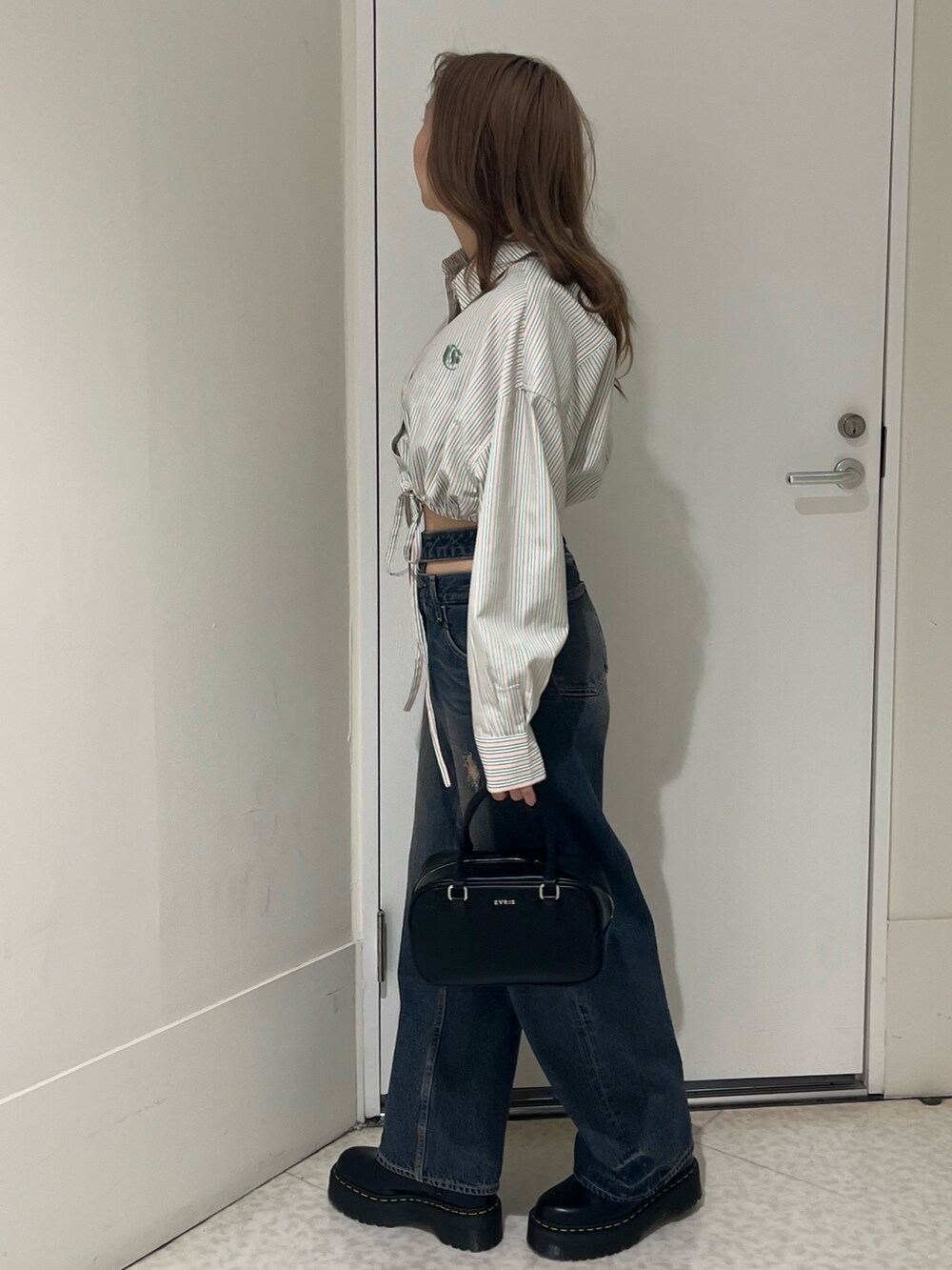 ブルー系のシャツ/ブラウス、ブルー系のデニムパンツ、ブラック系のブーツを着用したレディースの春コーディネートの3枚目の写真