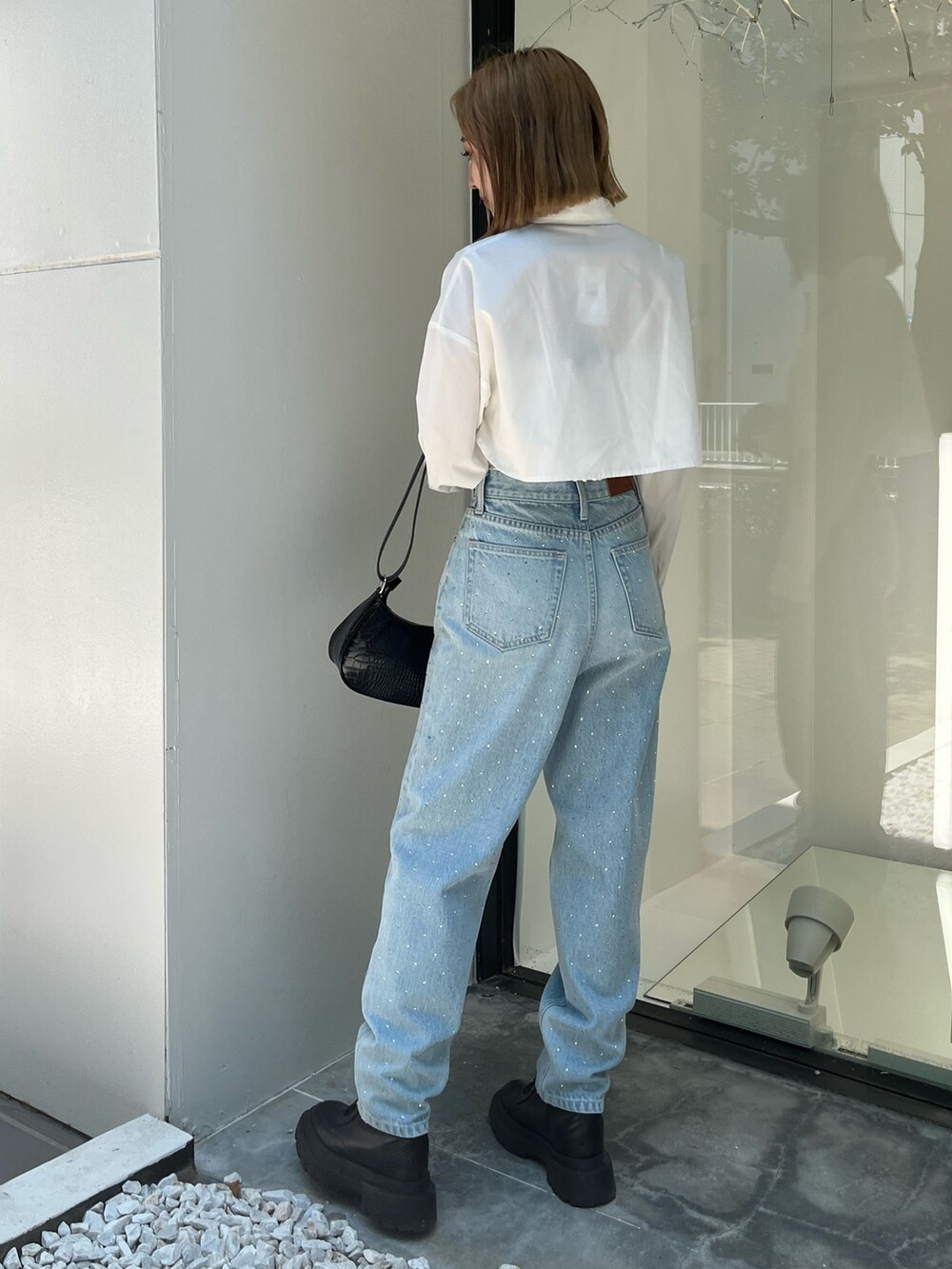 ホワイト系のシャツ/ブラウス、ブルー系のデニムパンツ、ブラック系のショルダーバッグを着用したレディースの秋コーディネートの3枚目の写真