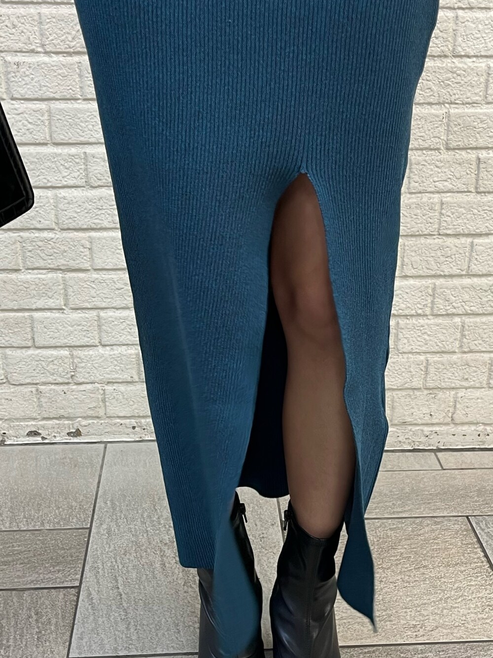 ブラック系のブルゾン、ブラック系のショルダーバッグ、ブルー系のワンピースを着用したレディースの冬コーディネートの8枚目の写真