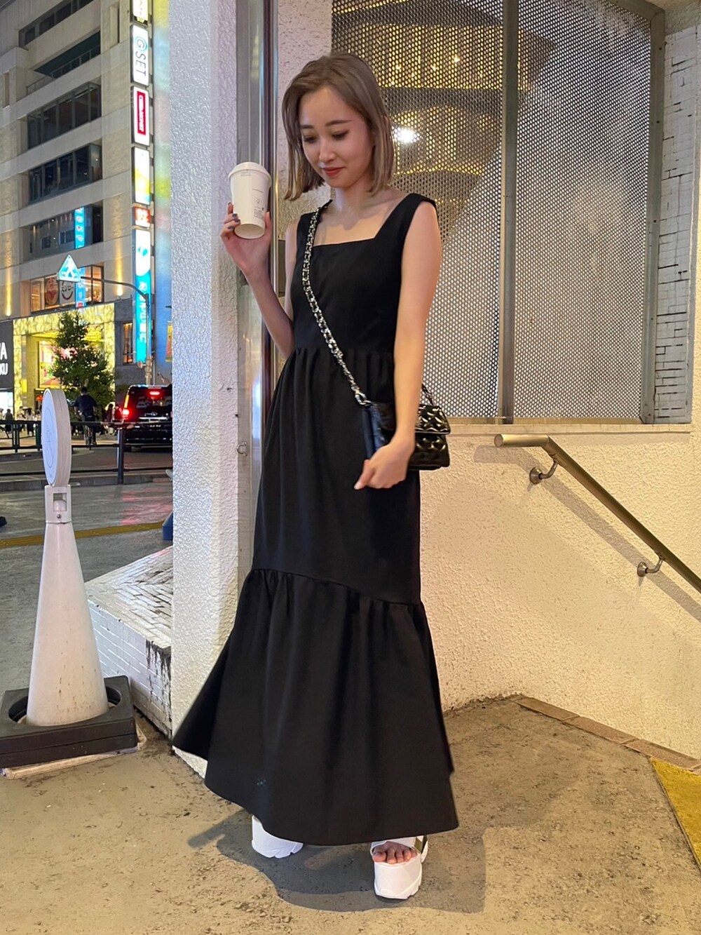 ブラック系のワンピース、ブラック系のショルダーバッグ、ホワイト系のサンダルを着用したレディースの夏コーディネートの5枚目の写真