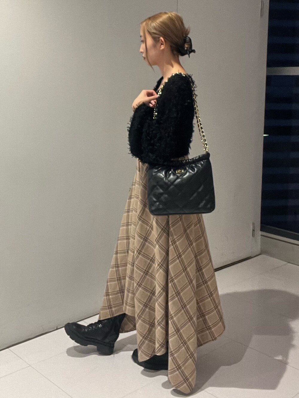 ブラック系のニット/セーター、ブラック系のワンピース、ブラック系のショルダーバッグを着用したレディースの秋コーディネートの2枚目の写真