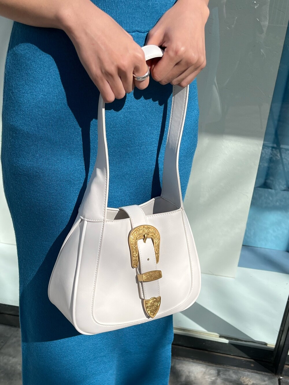 ブルー系のワンピース、ブラック系のハンドバッグを着用したレディースの春コーディネートの5枚目の写真