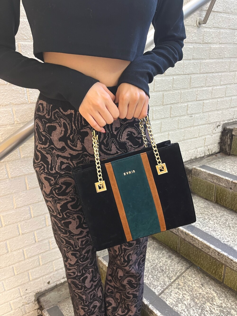 ホワイト系のその他アウター、ブラック系のその他パンツ、ブラック系のショルダーバッグを着用したレディースの冬コーディネートの9枚目の写真