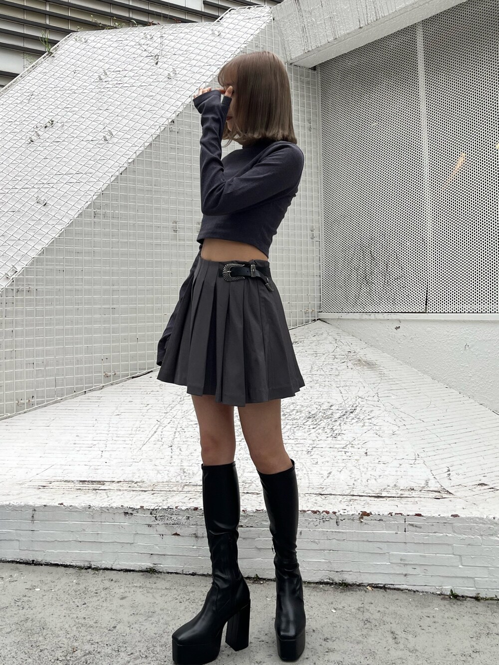 グレー系のスカート、グレー系のTシャツ/カットソー、ホワイト系のブーツを着用したレディースの秋コーディネートの2枚目の写真