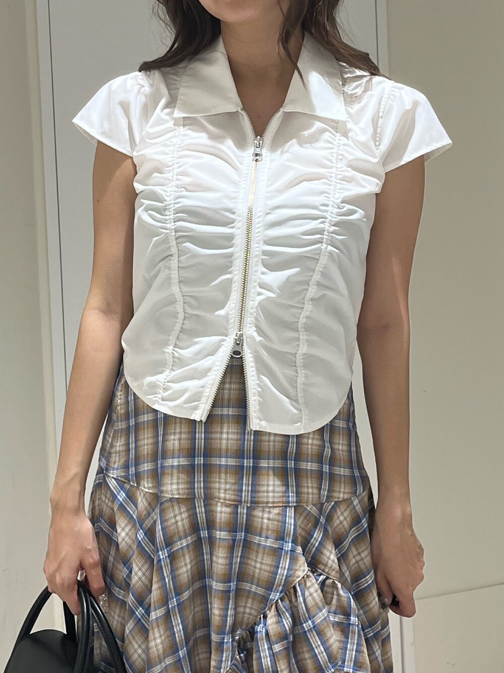 ブルー系のシャツ/ブラウス、ベージュ系のスカート、ブラック系のハンドバッグを着用したレディースの夏コーディネートの4枚目の写真