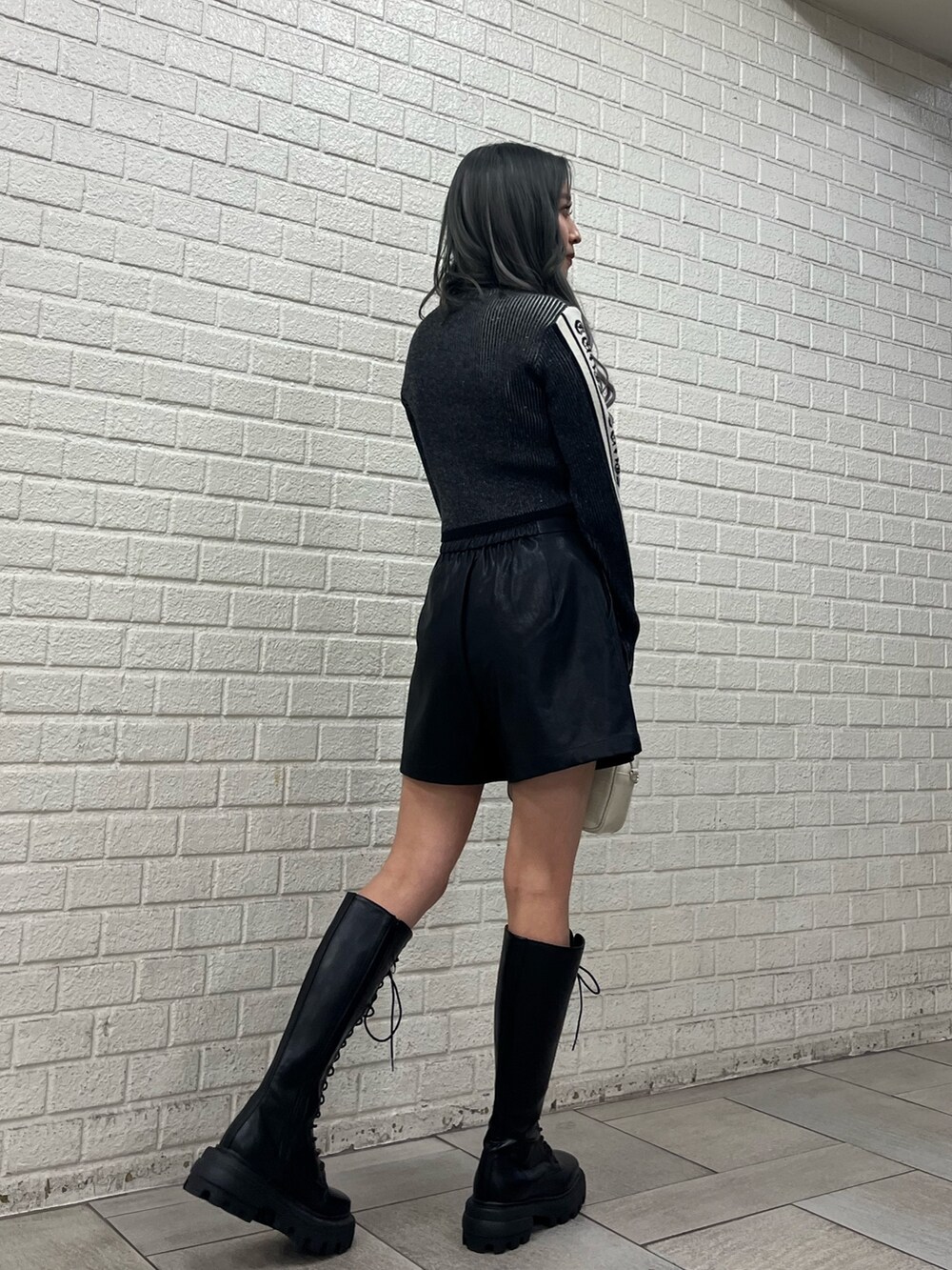 ベージュ系のその他パンツ、ブラック系のブーツ、ブラック系のショルダーバッグを着用したレディースの冬コーディネートの2枚目の写真