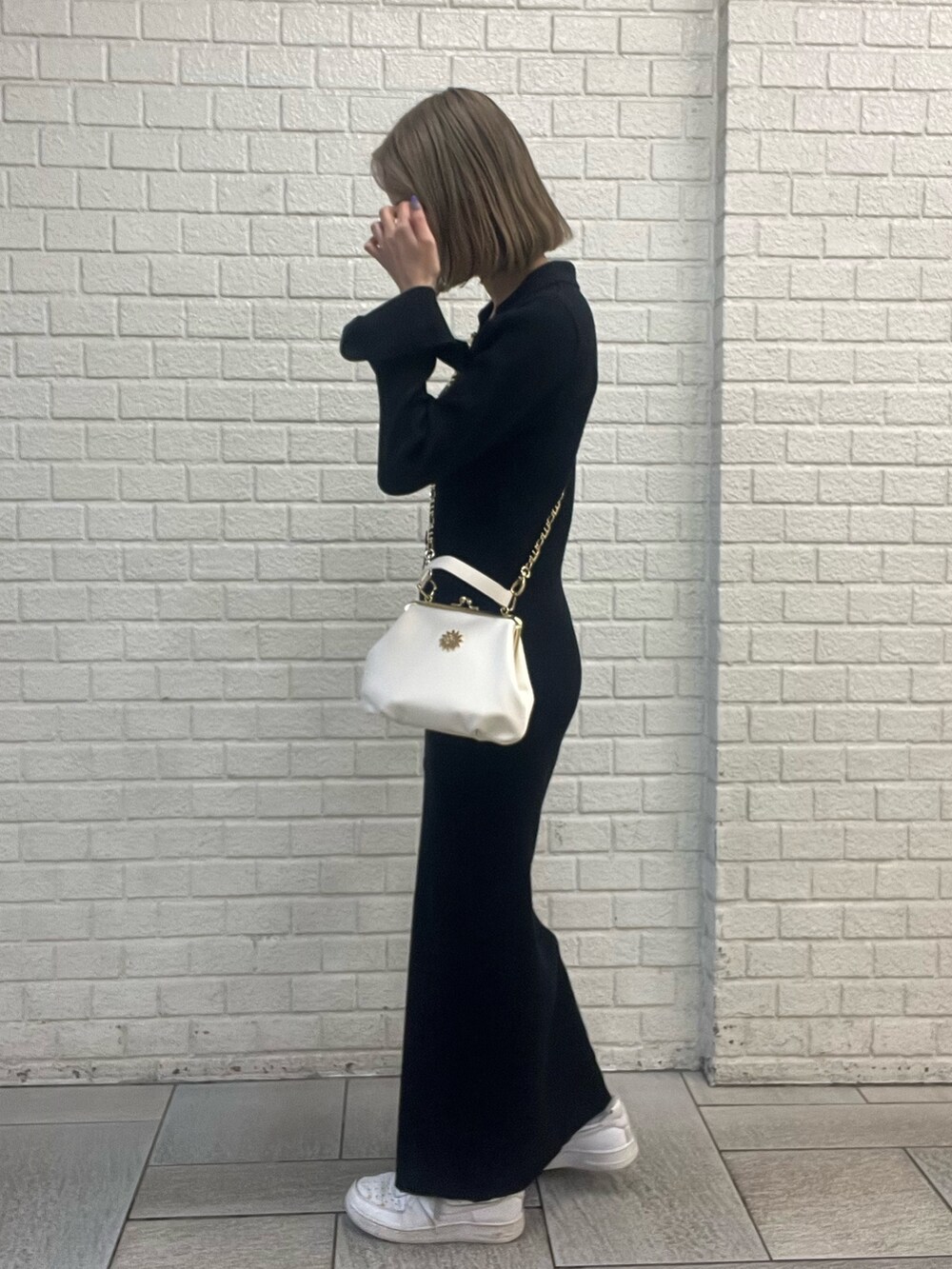 ブラック系のショルダーバッグ、ブラック系のワンピースを着用したレディースの冬コーディネートの2枚目の写真