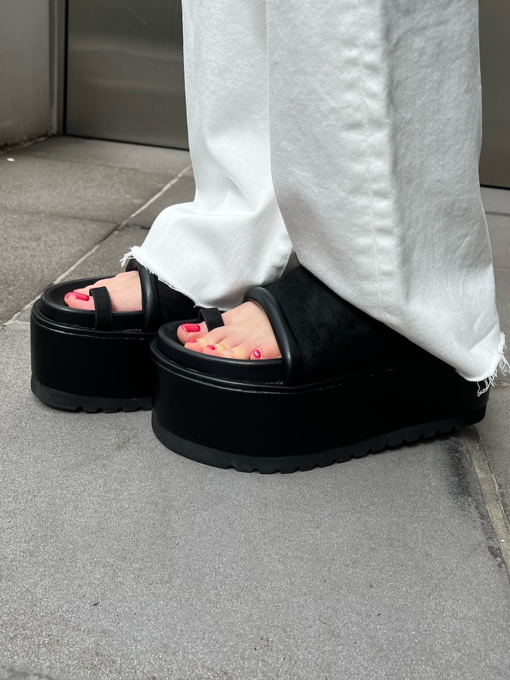 グリーン系のニット/セーター、ブラック系のデニムパンツ、ブラック系のショルダーバッグを着用したレディースの春コーディネートの6枚目の写真