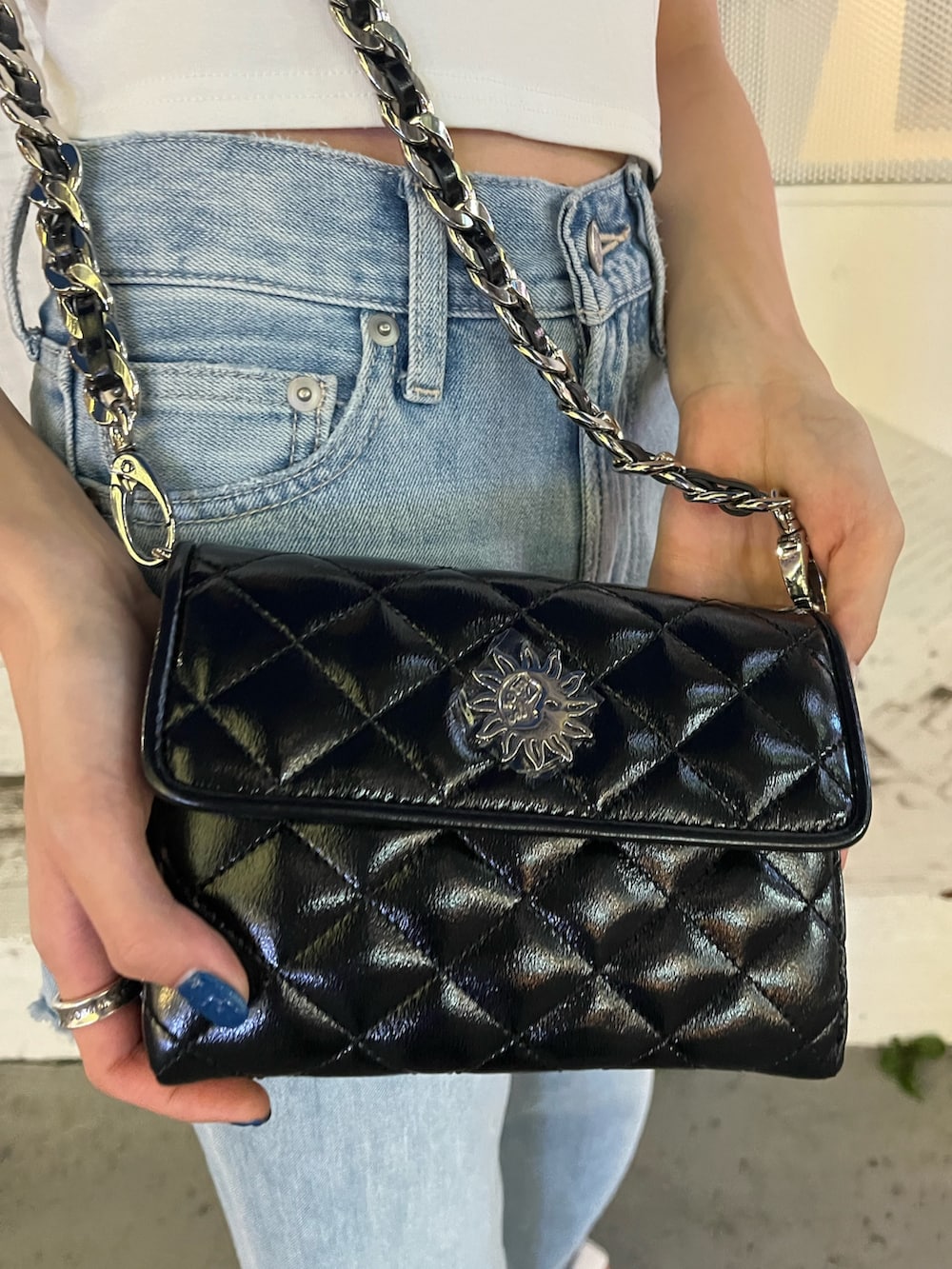 ブルー系のデニムパンツ、ホワイト系のTシャツ/カットソー、ブラック系のショルダーバッグを着用したレディースの夏コーディネートの8枚目の写真