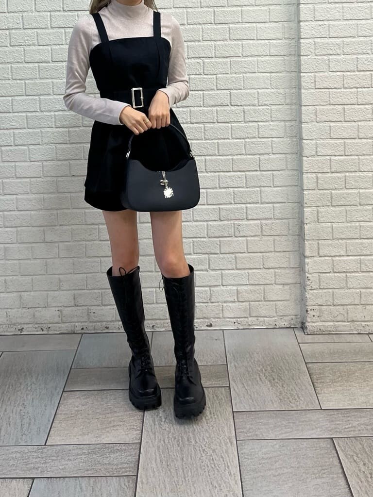 ブラック系のブーツ、ブラック系のハンドバッグ、ホワイト系のTシャツ/カットソーを着用したレディースの秋コーディネートの3枚目の写真