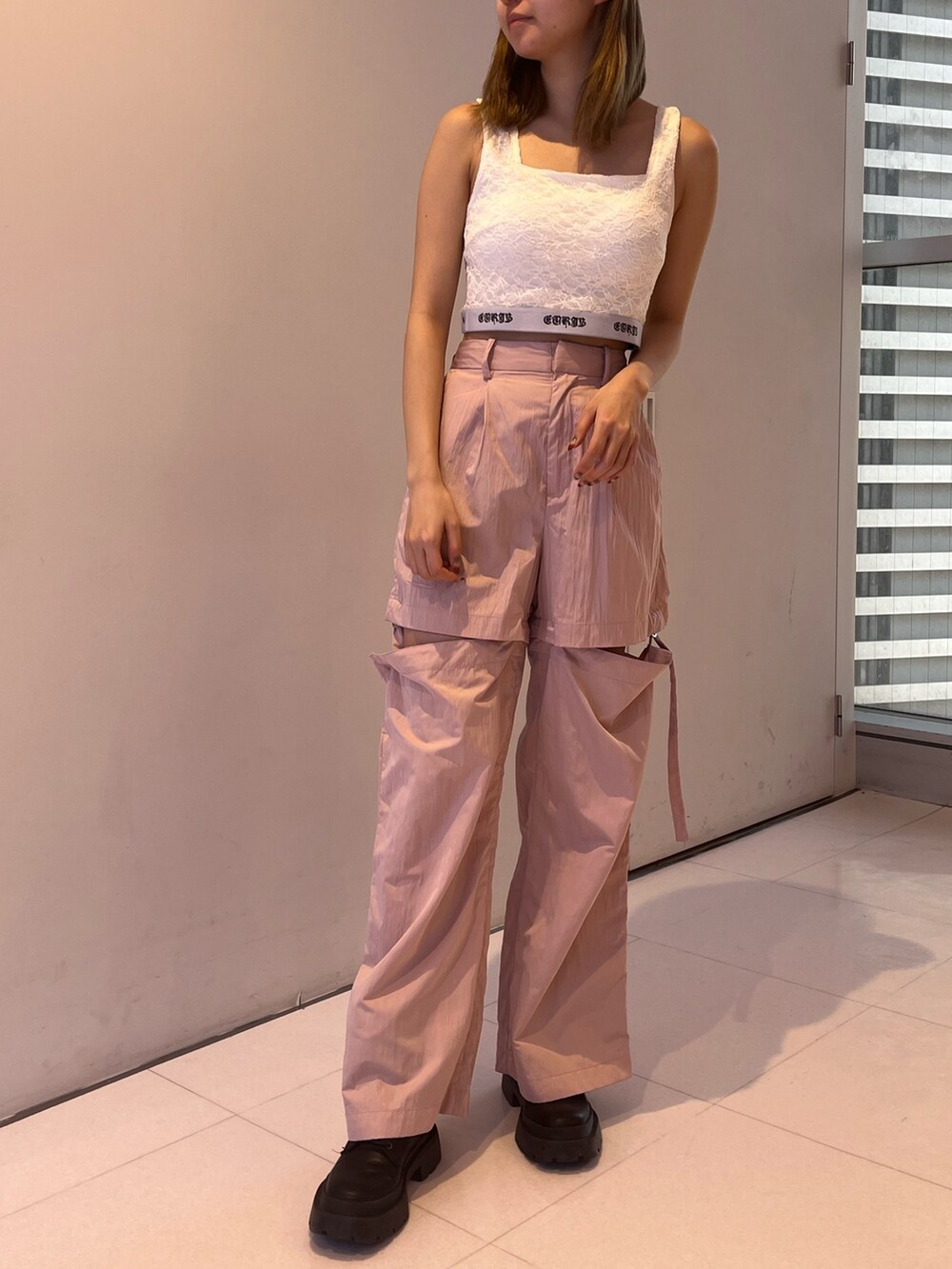 ピンク系のカーゴパンツ、ブラック系のキャミソール、ブラック系のニット/セーターを着用したレディースの春コーディネートの6枚目の写真