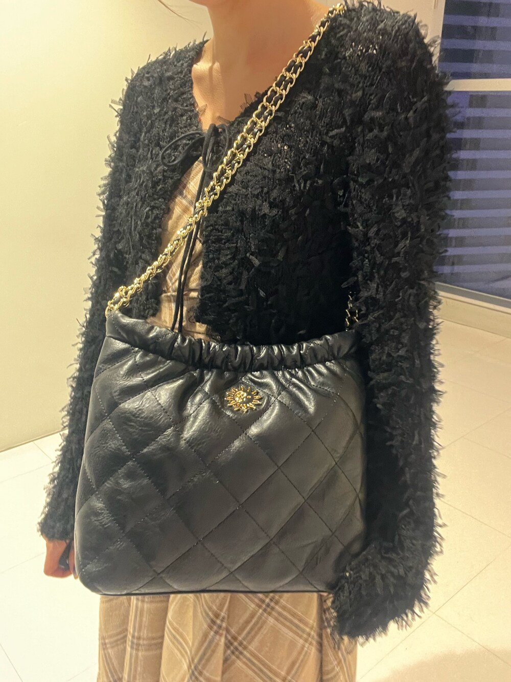 ブラック系のニット/セーター、ブラック系のワンピース、ブラック系のショルダーバッグを着用したレディースの秋コーディネートの5枚目の写真