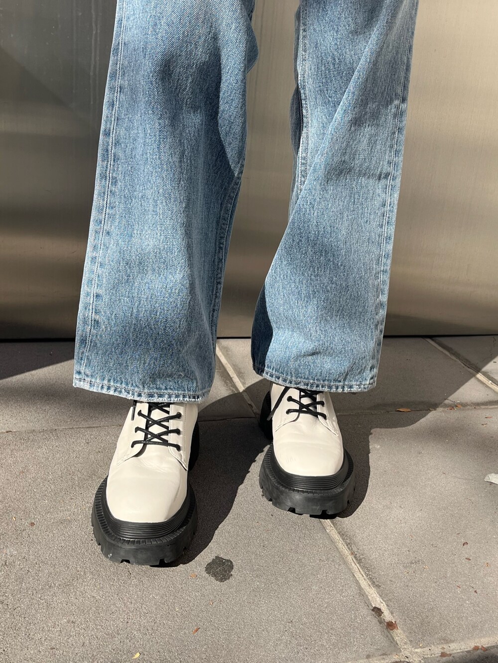 ブルー系のデニムパンツ、ホワイト系のショルダーバッグ、ピンク系のカーディガン/ボレロを着用したレディースの冬コーディネートの5枚目の写真