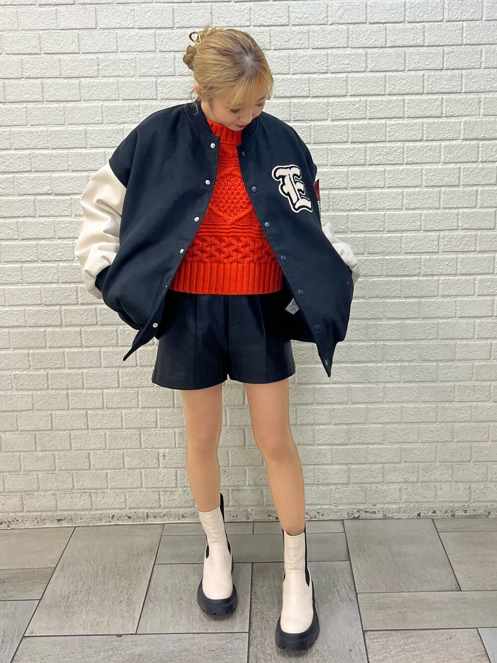 ホワイト系のブーツ、ブラック系のその他パンツ、ホワイト系のニット/セーターを着用したレディースの冬コーディネートの6枚目の写真