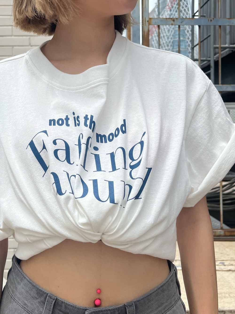 ブラック系のデニムスカート、ブラック系のサンダル、ホワイト系のTシャツ/カットソーを着用したレディースの夏コーディネートの7枚目の写真