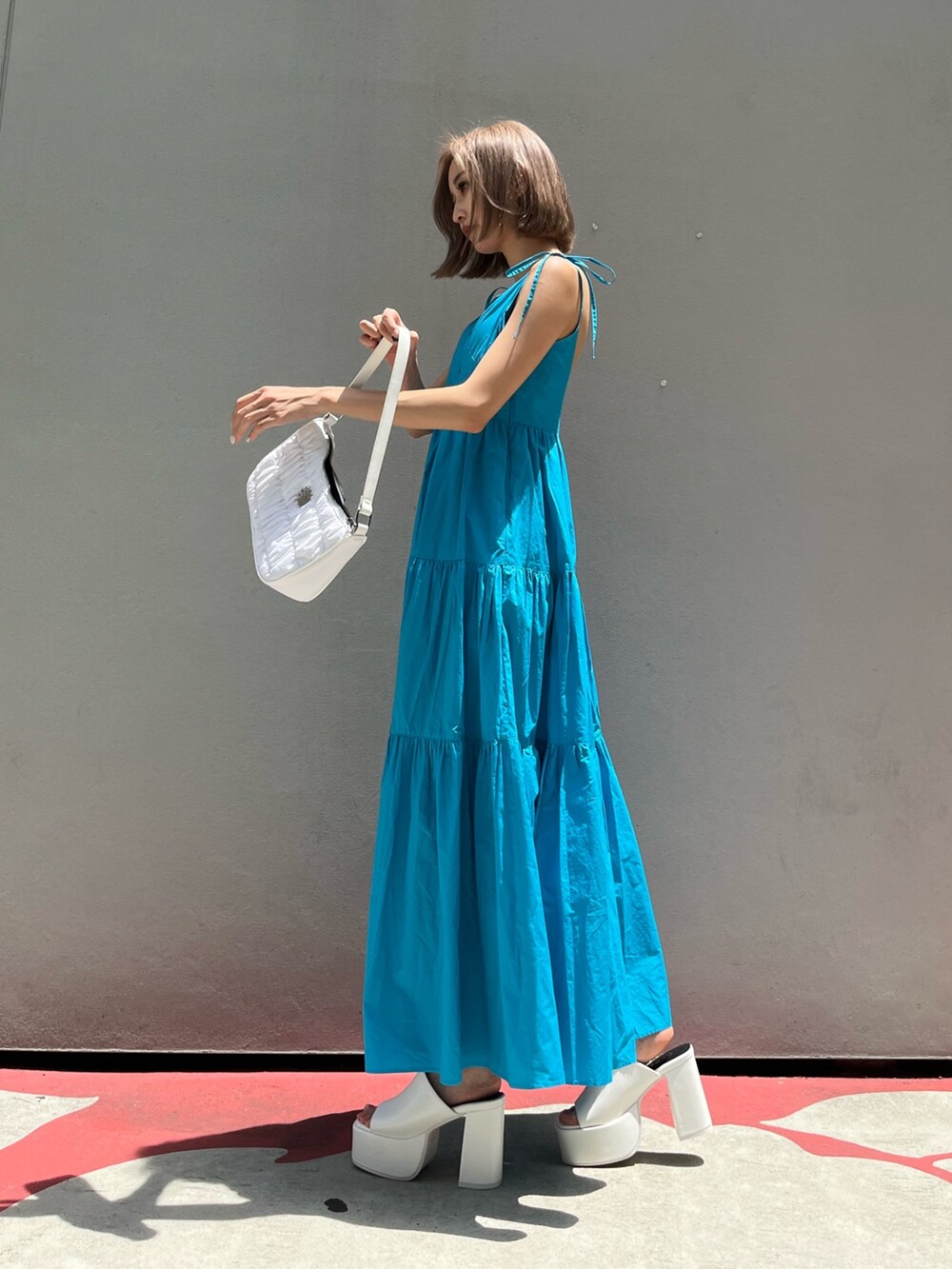 ホワイト系のサンダル、ブラック系のワンピースを着用したレディースの夏コーディネートの3枚目の写真