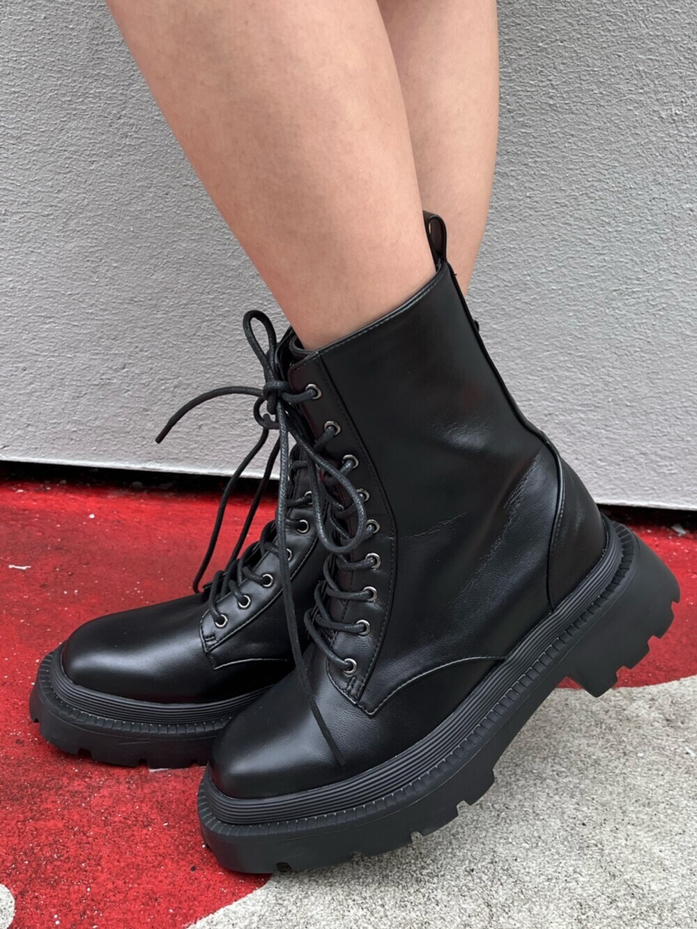 ブラック系のブーツ、ベージュ系のワンピース、レッド系のショルダーバッグを着用したレディースの夏コーディネートの7枚目の写真