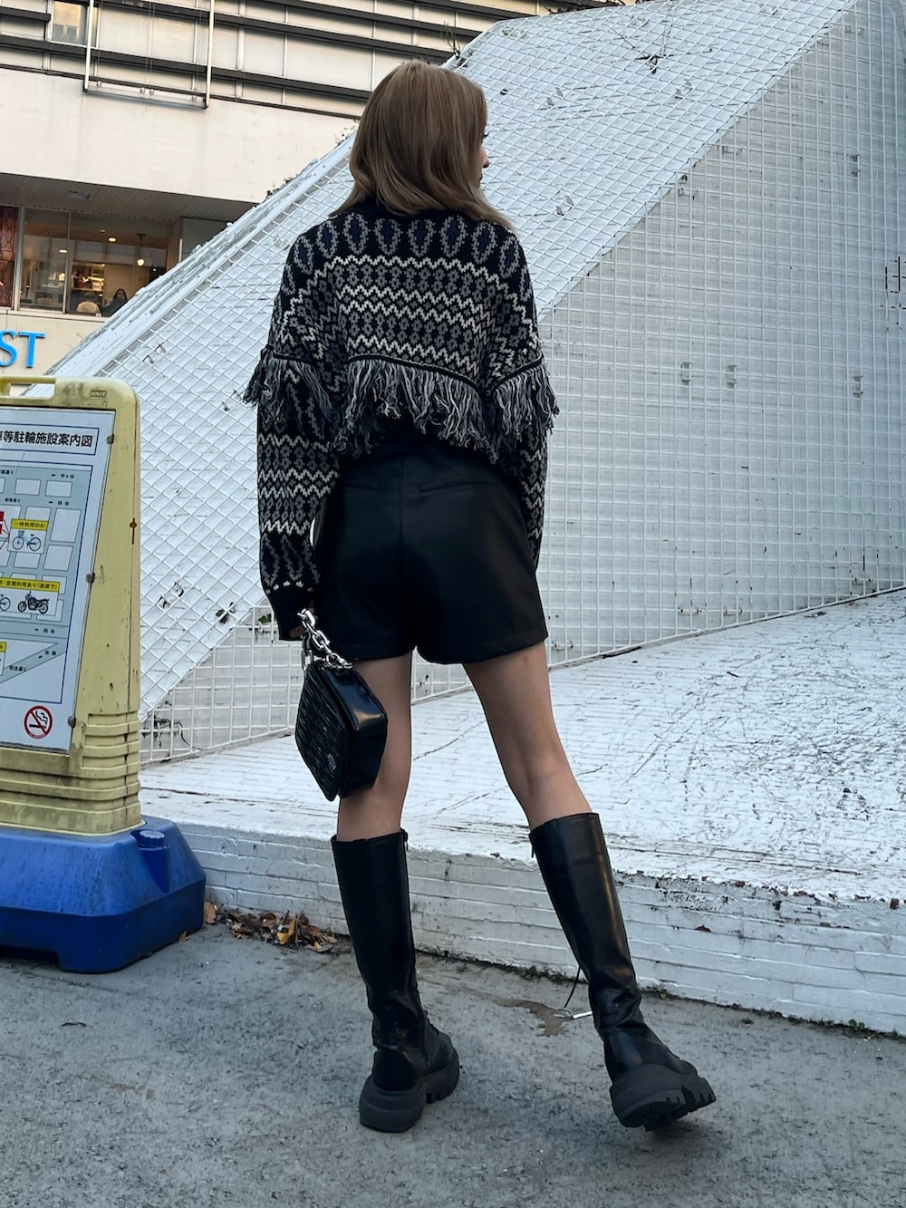 ブラック系のニット/セーター、ベージュ系のその他パンツ、ブラック系のブーツを着用したレディースの冬コーディネートの4枚目の写真