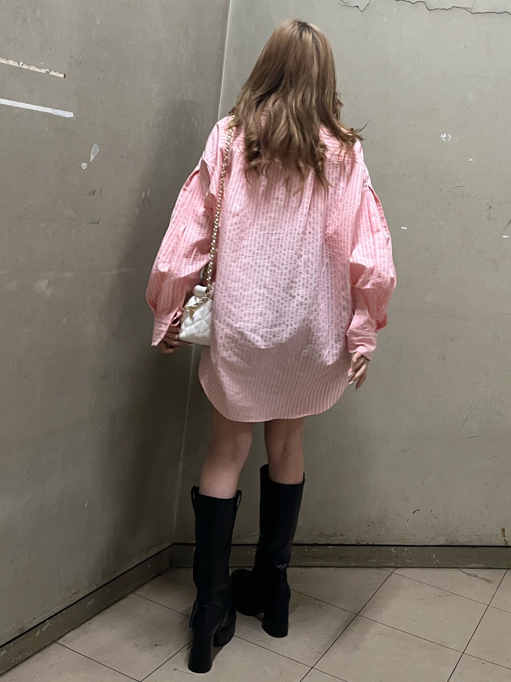 グリーン系のシャツ/ブラウス、ホワイト系のショルダーバッグ、ブラック系のブーツを着用したレディースの春コーディネートの3枚目の写真