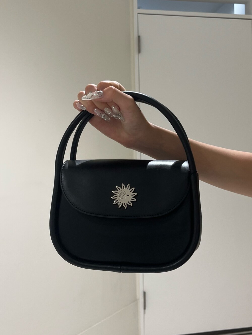 ブラック系のワンピース、ブラック系のハンドバッグ、ブラック系のブーツを着用したレディースの夏コーディネートの4枚目の写真