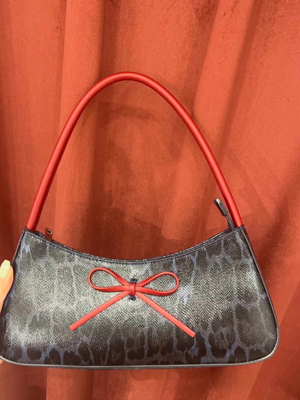 ブルー系のデニムパンツ、ブラウン系のハンドバッグ、ブラック系のブーツを着用したレディースの春コーディネートの6枚目の写真